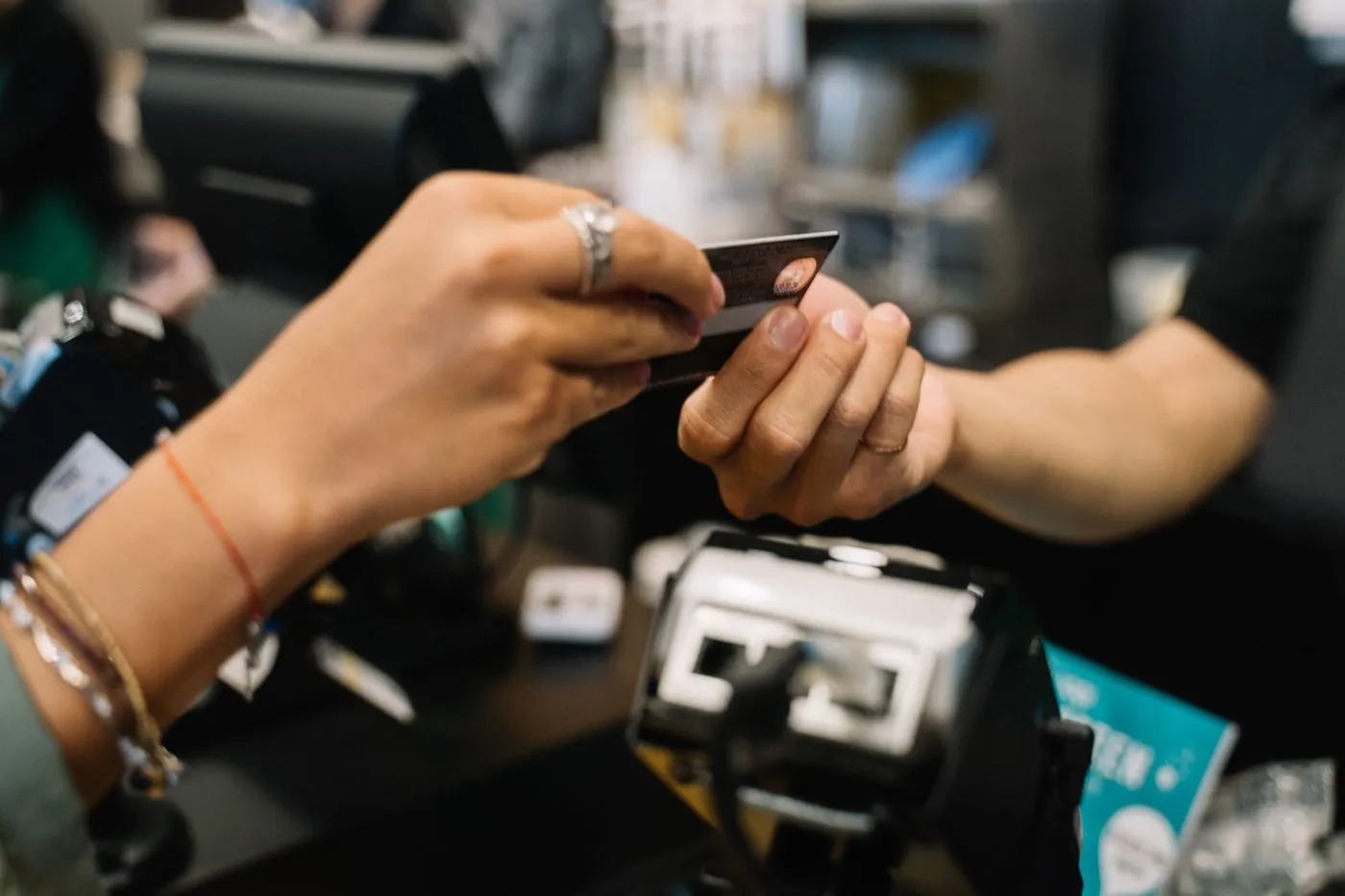 Cliente porge una carta di credito alla cassa di un negozio per pagare